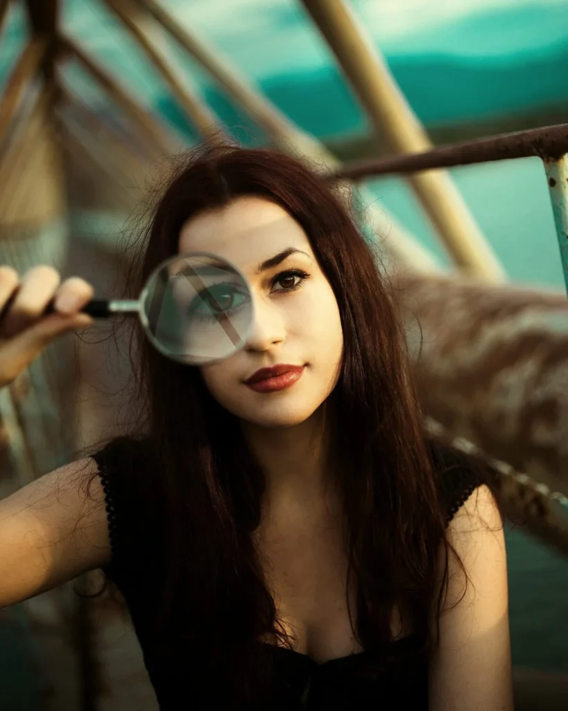 A woman holding a magnifying glass to one eye, the close examination Kingster Local brings to a business during consulting.