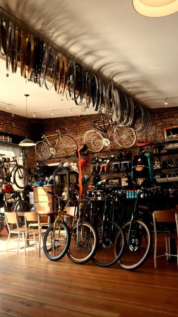 Bicycle shop interior with wheels mounted along the ceiling and bikes on a brick wall, Santa Fe NM